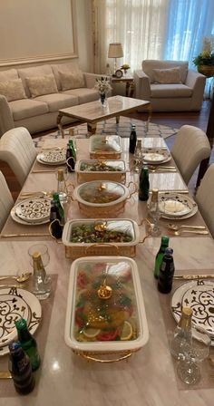 a dining room table is set with dishes and place settings