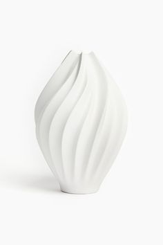 a white vase sitting on top of a table