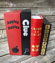 three books are stacked on top of each other, one is red and the other is black