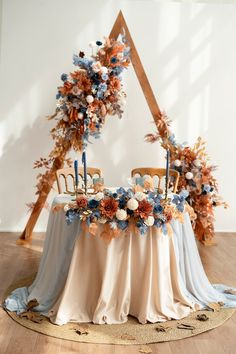 an arrangement of flowers and foliage decorates the centerpiece of a table with two chairs