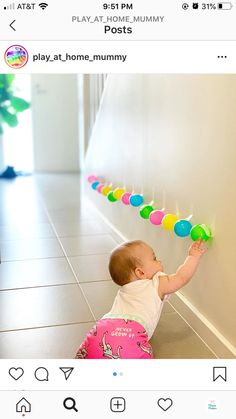 a baby is playing with some candy lollipops on the wall in front of her