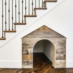 an empty dog house under the stairs