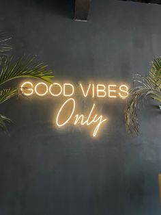 a neon sign that says good vibes only on the side of a black wall