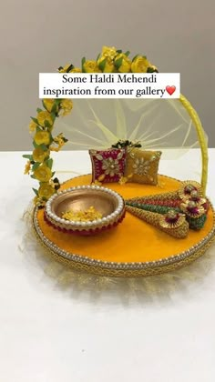 a yellow tray with decorative items on it and a sign that says some haldi meheri inspiration from our gallery