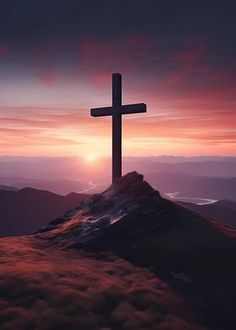 a cross on top of a mountain at sunset