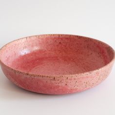 a pink bowl sitting on top of a white table