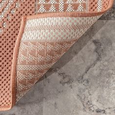 an orange and white rug sitting on top of a marble floor