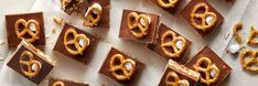 chocolate and pretzels are arranged on a sheet of paper