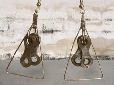 two pairs of metal earrings hanging from hooks