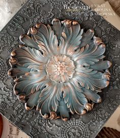 an ornate metal plate sitting on top of a table