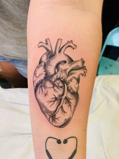 a black and white heart tattoo on the arm