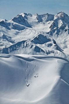 snow covered mountains with tracks in the snow