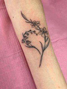 a small flower tattoo on the arm