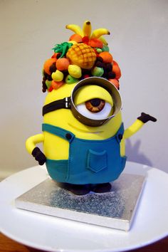 a cake that looks like a minion with fruit on it's head and eyes