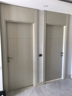 an empty room with two white doors in it