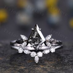 an engagement ring with two pear shaped diamonds on the top and one pear shaped diamond in the middle