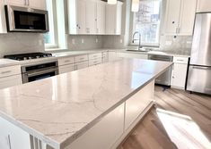 a kitchen with marble counter tops and stainless steel appliances in the middle of the room