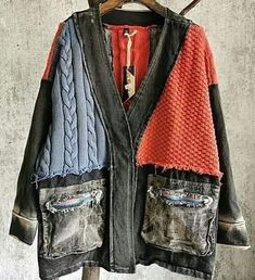 an old jacket hanging on a clothes rack with two pairs of jeans in the pocket