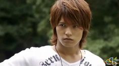 a young man with brown hair wearing a white t - shirt