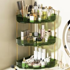 three tiered green shelf with cosmetics and personal care items on it next to a mirror