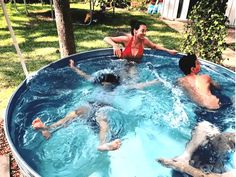 three people are in the pool and one person is on his knees, while another man sits