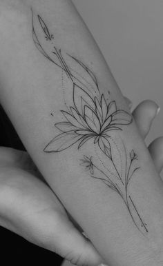 a woman's arm with a flower tattoo on it