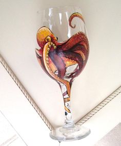 an octopus wine glass sitting on top of a counter next to a roped wall