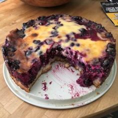 a blueberry cheesecake on a plate with one slice missing