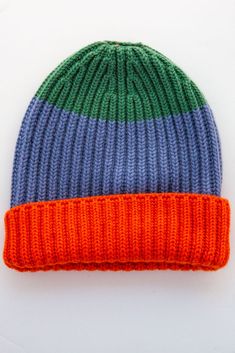 an orange, blue and green knitted beanie on a white background with clippings