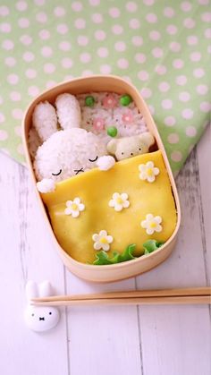 a bento box filled with rice and two small stuffed animals