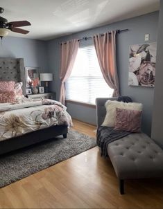 a bed room with a neatly made bed and a chair in front of a window