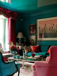 a living room with blue walls and pink furniture