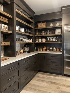 a kitchen with gray cabinets and wooden shelves