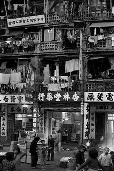 an old black and white photo of people in front of a building with many balconies