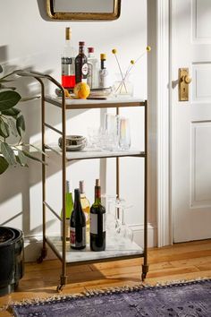 a bar cart with bottles and glasses on it