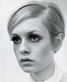 a black and white photo of a woman with eyeliners looking at the camera