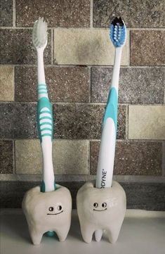 two toothbrushes sitting next to each other in front of a brick wall,