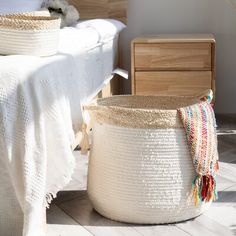 a white bed with two baskets on top of it