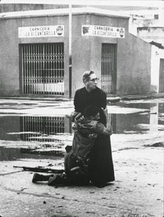 an old black and white photo with a woman sitting on the ground