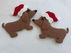 two felt dachshund dogs wearing santa hats