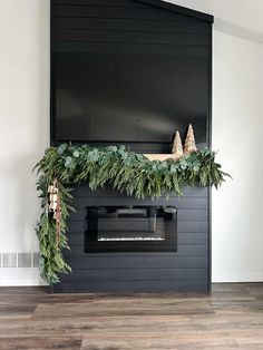 a fireplace decorated for christmas with greenery and cones