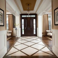 an entry way with two chairs and pictures on the wall above it, along with a door leading to another room