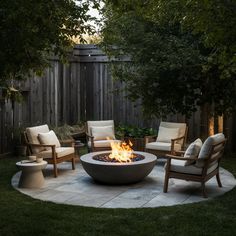 an outdoor fire pit with chairs around it