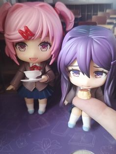 two figurines sitting next to each other on a table