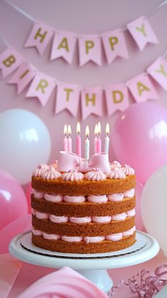 a birthday cake with pink frosting and lit candles