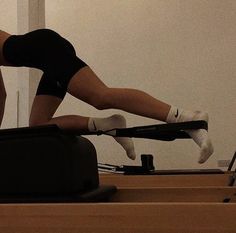 a woman is doing exercises on a treadmill while holding her leg in the air