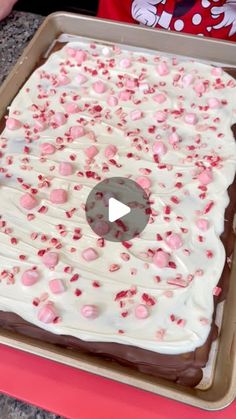 a cake with white frosting and pink sprinkles on it in a pan