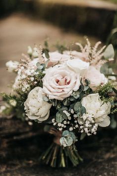 a bouquet of white and pink flowers on the ground