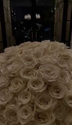 a large bouquet of white roses sitting on top of a table