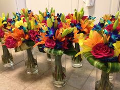 four vases filled with colorful flowers on the floor